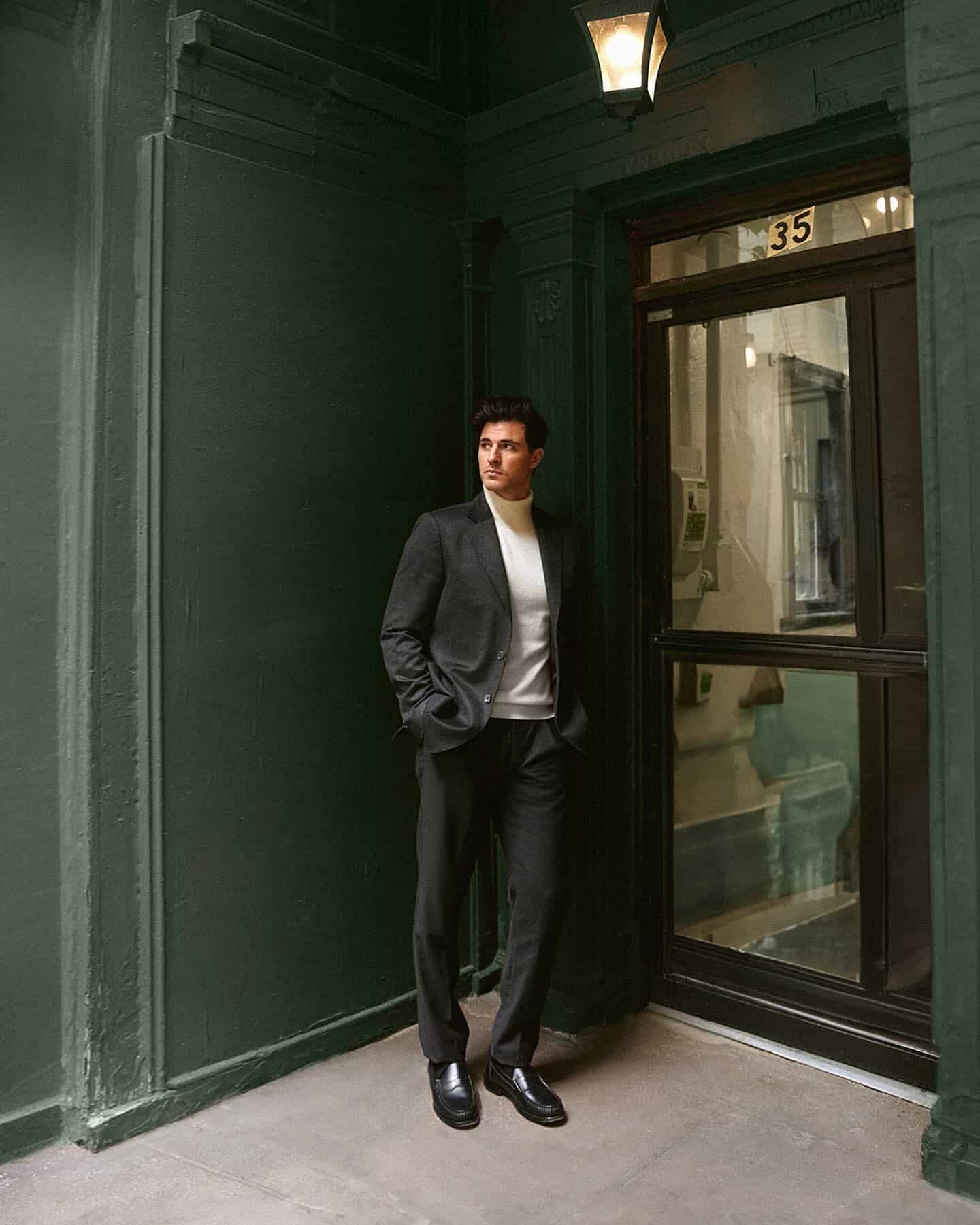 homem parado perto da porta vestindo um blazer de caxemira