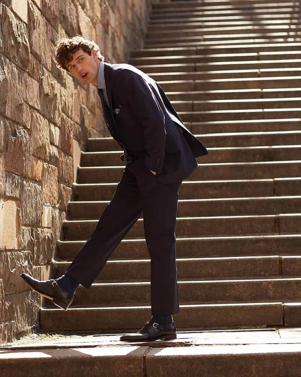 man on the stairs wearing a navy suit