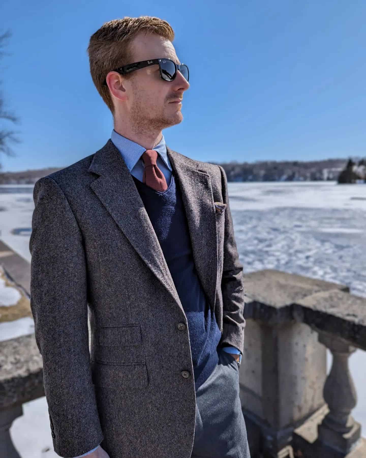 man with sunglasses wearing a tweed suit jacket
