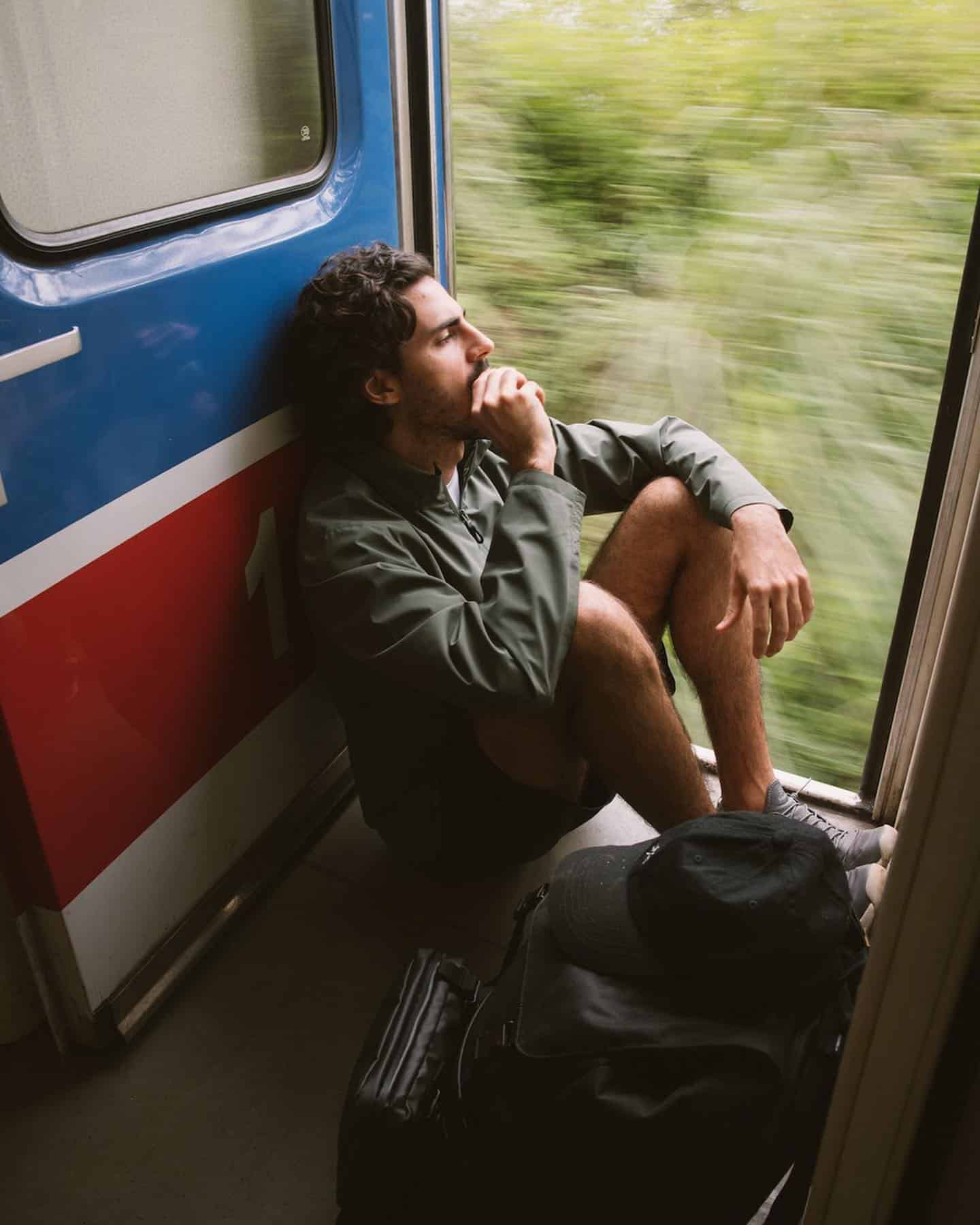 Gorpcore style: man on a train wearing a light jacket