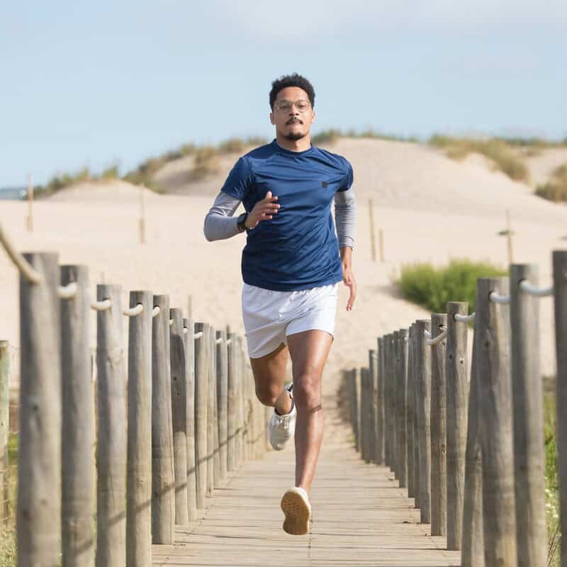 man running in a narrow wooden bridge