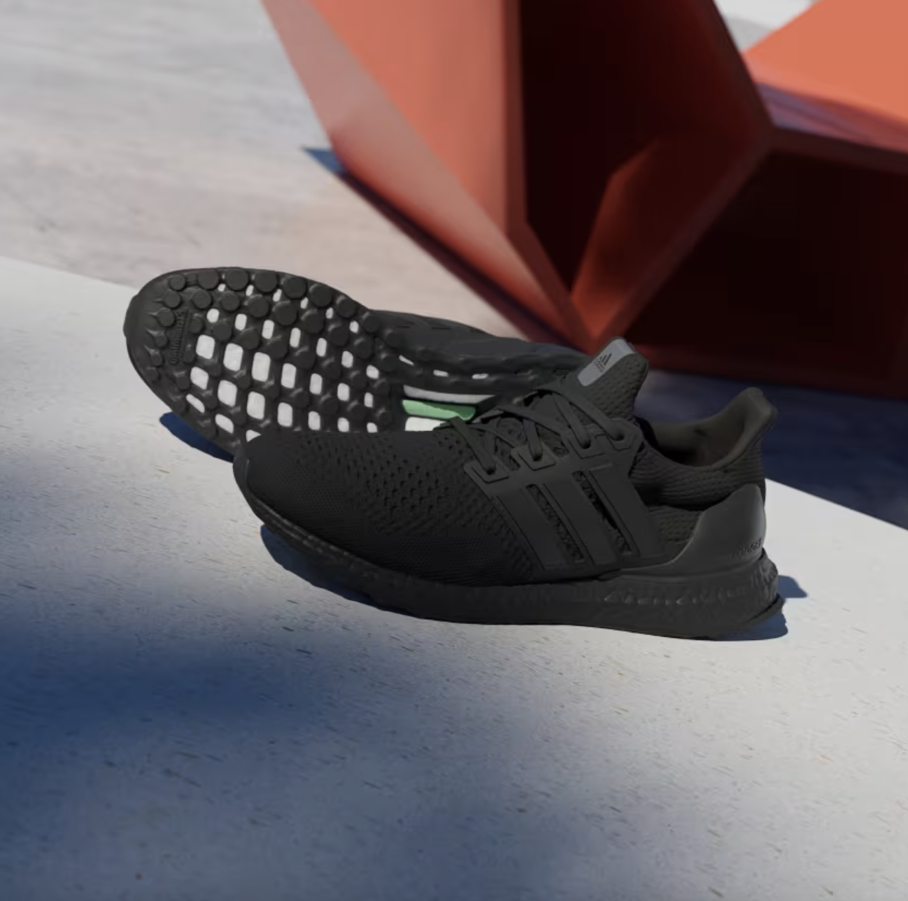 Black Adidas running shoes with breathable mesh upper and Boost midsole for comfort. Perfect for active lifestyles and athletic training, showcasing sleek design and premium footwear technology.